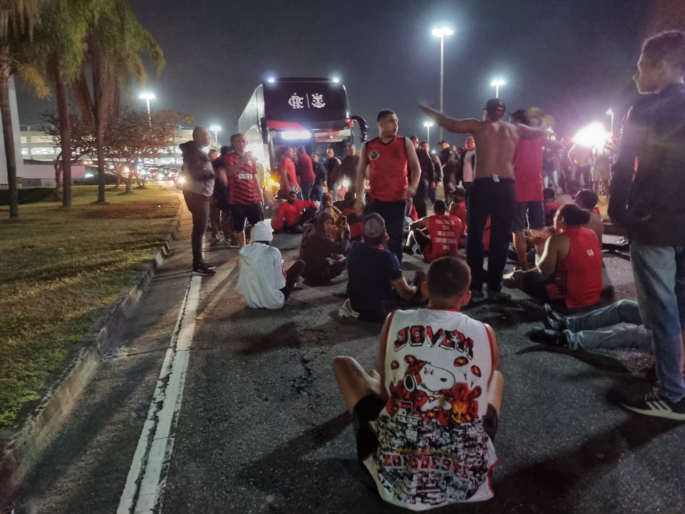 Torcedores do Flamengo sentam em via para tentar impedir avanço do ônibus com jogadores, no entorno do Galeão — Foto: Ronald Lincoln/ge