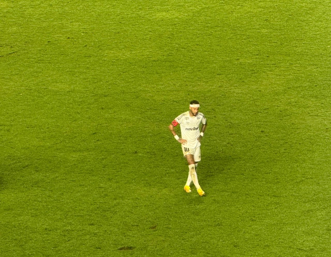 Neymar com expressão de dor, segurando a coxa direita durante partida na Vila Belmiro