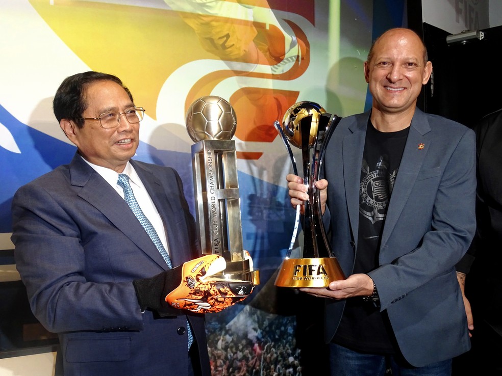 Ph?m Minh Chính, primeiro-ministro do Vietnã, e Luiz Wagner Alcantara, vice-presidente do Corinthians, com taças dos Mundiais do clube — Foto: Kaíque Mariano Idalgo/ Agência Corinthians