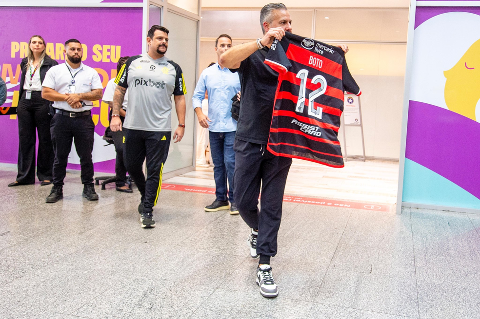 Boto mostra camisa do Flamengo com seu nome para as câmeras na chegada