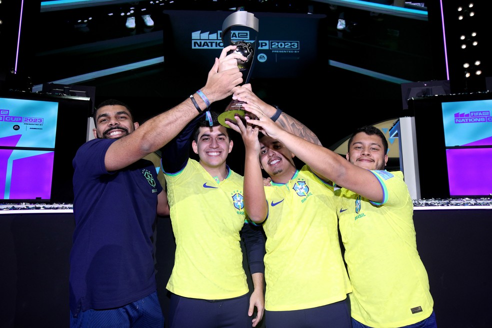 Jogadores da seleção brasileira de FIFA 23 levantando o troféu do FIFAe Nations Cup 2023, a Copa do Mundo do game — Foto: FIFA