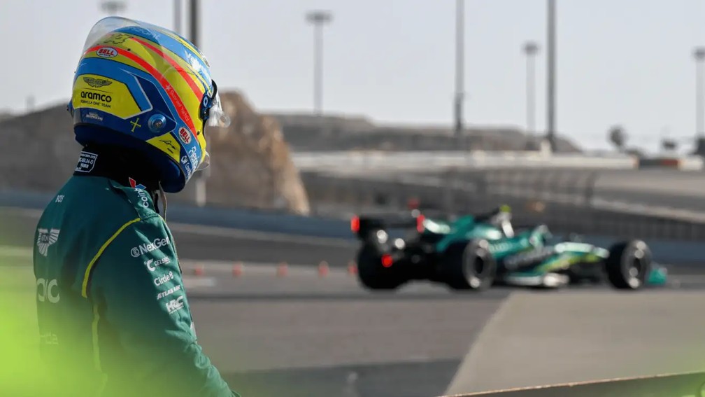 Fernando Alonso olha seu Aston Martin parado na pista durante os testes da F1 no Bahrein — Foto: Reprodução