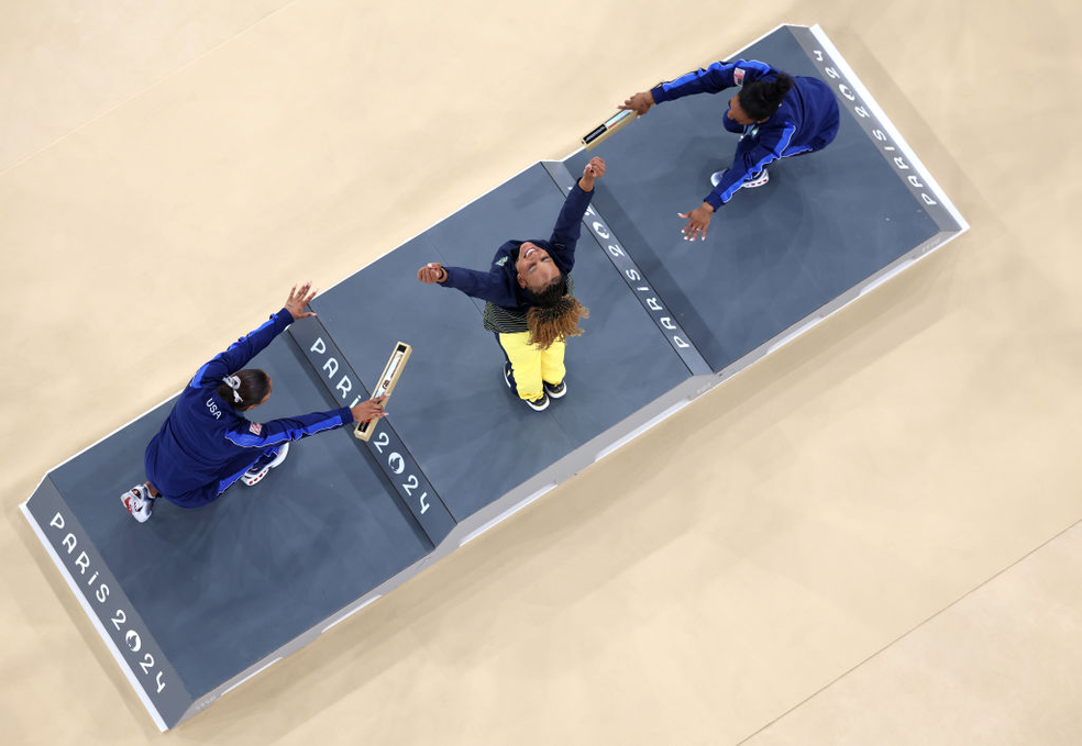 Rebeca Andrade sendo reverenciada por Simone Biles e Jordan Chiles no p�dio do solo em Paris 2024 � Foto: Dan Mullan/Getty Images