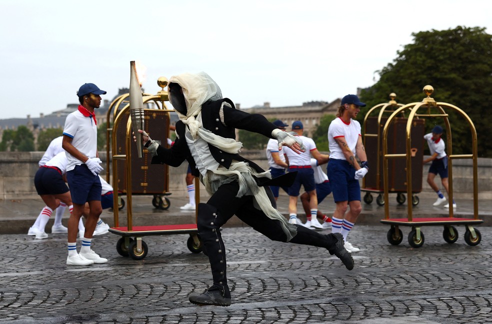 O mascarado misterioso correndo com a tocha olmpica em Paris, na cerimnia de abertura das Olimpadas 2024  Foto: Maddie Meyer/Pool via REUTERS