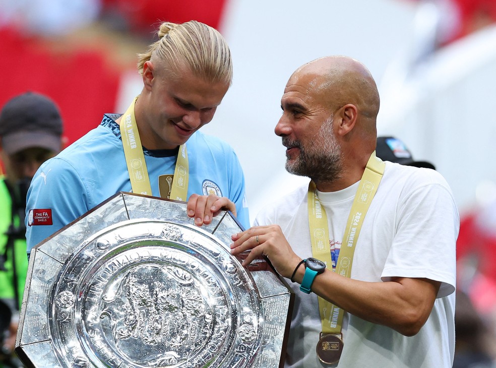 Haaland e Guardiola com o trof&eacute;u da Supercopa da Inglaterra &mdash; Foto: Toby Melville / Reuters