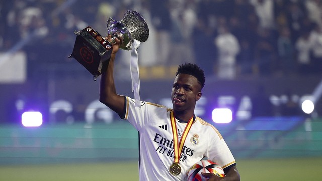 Vinicius Junior, do Real Madrid, com a taça da Supercopa e a bola do jogo após hat-trick em cima do Barcelona