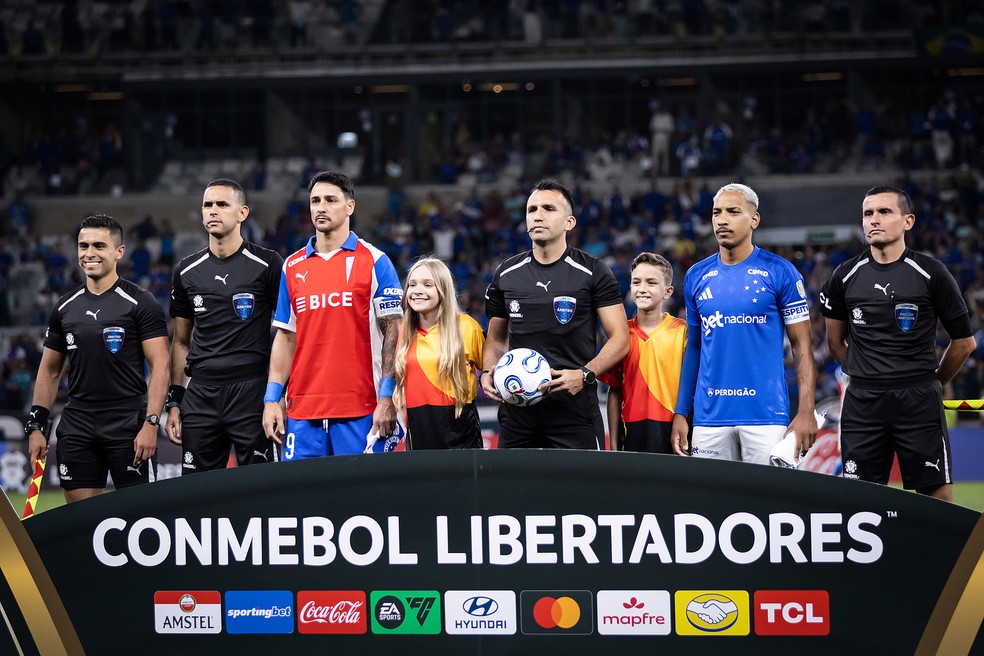 Matheus Pereira, capitão do Cruzeiro, com árbitro do jogo contra a Universidad Católica — Foto: Gustavo Aleixo/Cruzeiro