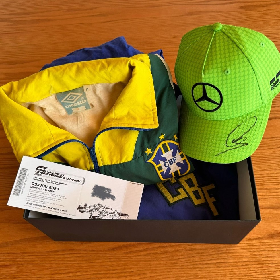Kit entregue pela equipe de Lewis Hamilton, com boné autografado e dois ingressos para a F1 — Foto: Arquivo Pessoal
