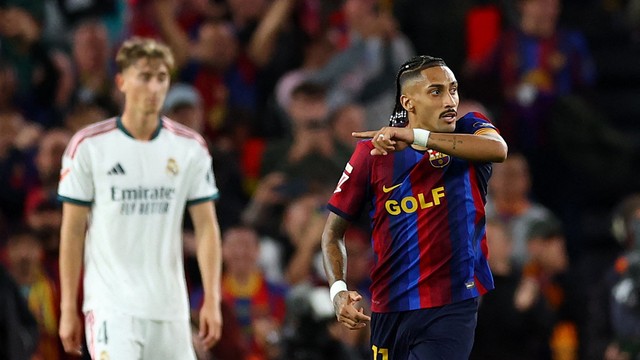 Raphinha comemora diante de Huijsen em Barcelona x Real Madrid