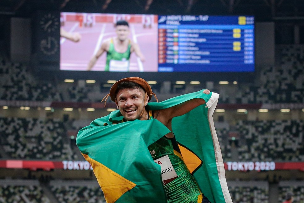 Petrúcio Ferreira comemora com chapéu de couro e bandeira do Brasil o título dos 100m T47 — Foto: Wander Roberto /CPB @wander_imagem