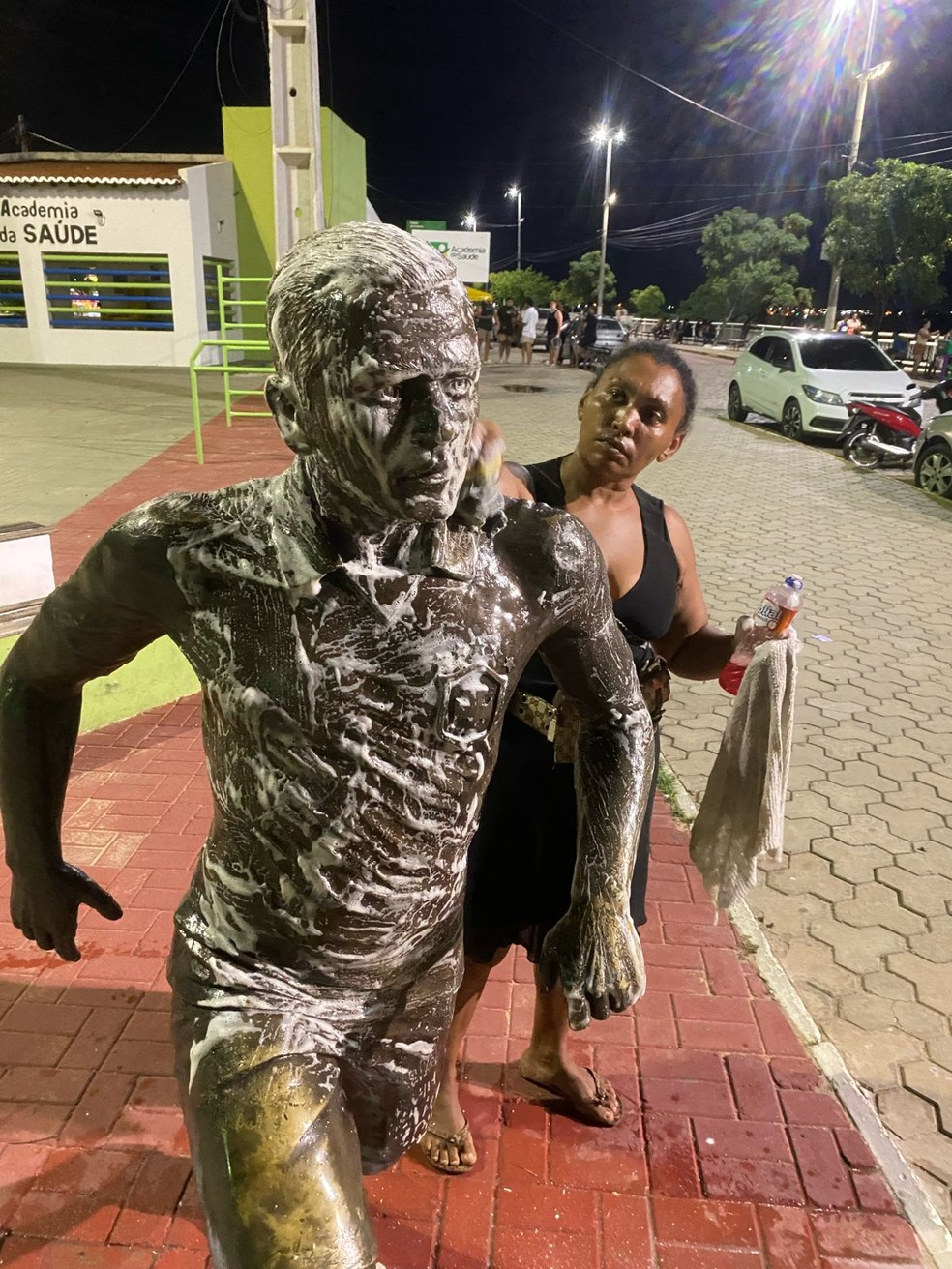 Moradora de Juazeiro limpa estátua de Daniel Alves — Foto: Jacira Felix/Juá Notícias
