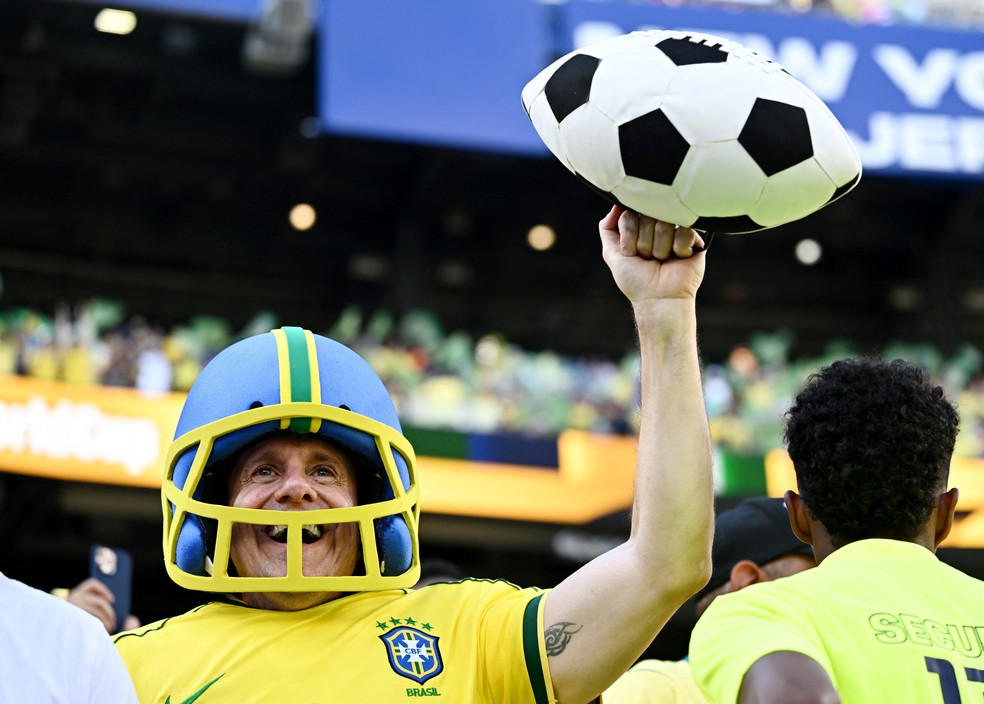 Torcedor vestido com a camisa do Brasil e elementos do futebol americano