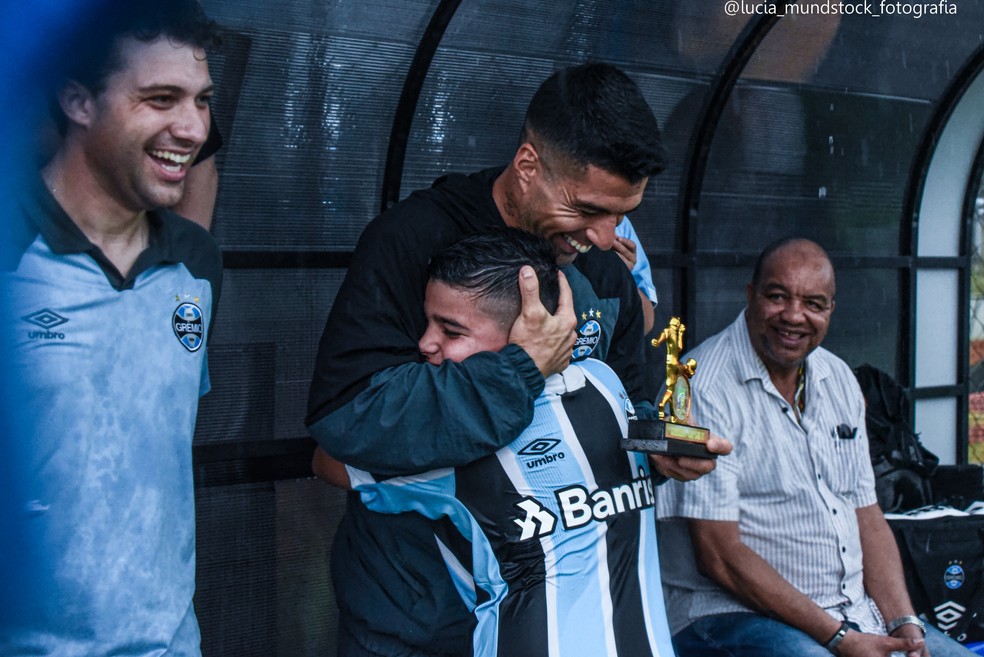 Criança do sub-11 do Grêmio abraça Suárez em premiação no CT da Escola de Formação — Foto: Lucia Mundstock/Arquivo pessoal