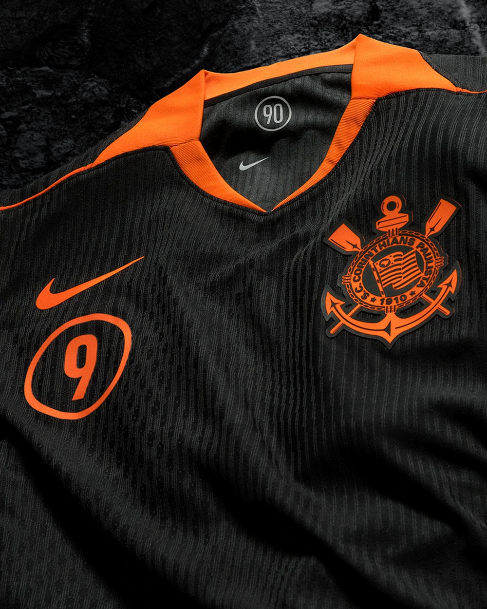 Detalhe do escudo e golas laranja na nova camisa III Corinthians