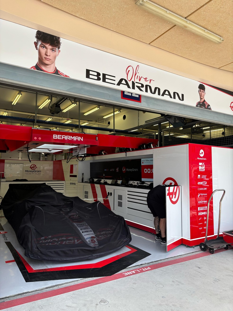 Carro de Oliver Bearman, da Haas, coberto por tela antes de corrida — Foto: Rodrigo França