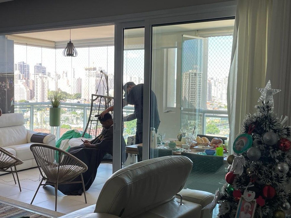 Endrick cortando o cabelo na varanda de casa, e o café da manhã posto na mesa — Foto: Camila Alves