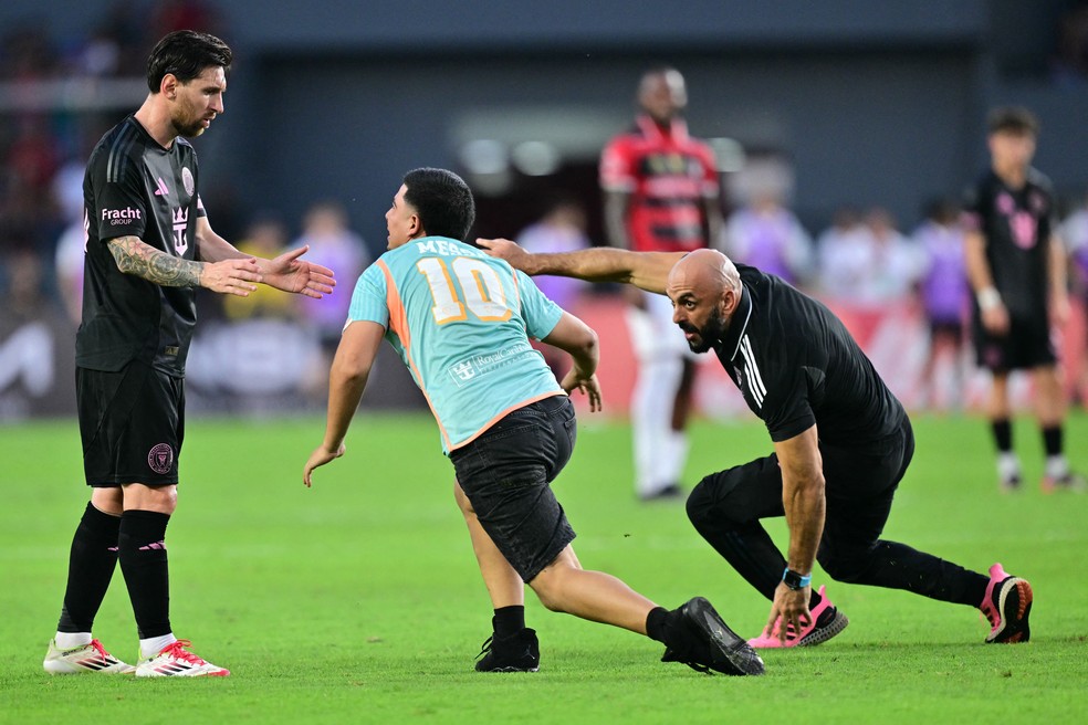 Torcedor invade o campo e dribla o segurança para abraçar Lionel Messi em amistoso no Panamá — Foto: MARTIN BERNETTI / AFP