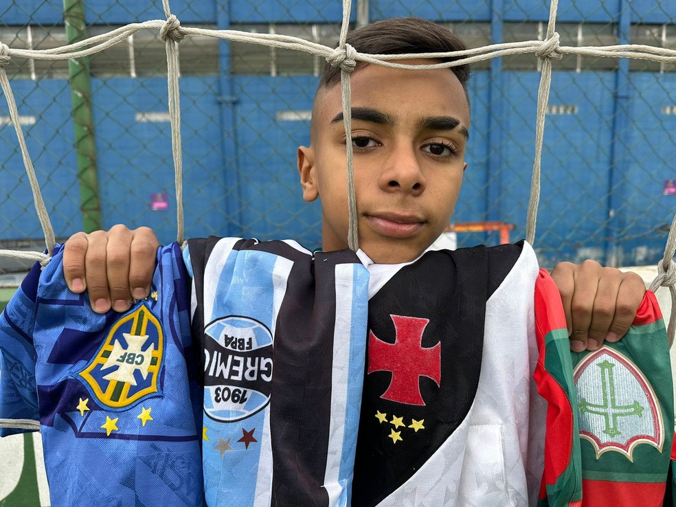 Neto de Dener posa com as camisas que o avô vestiu ao longo da carreira  — Foto: Emilio Botta