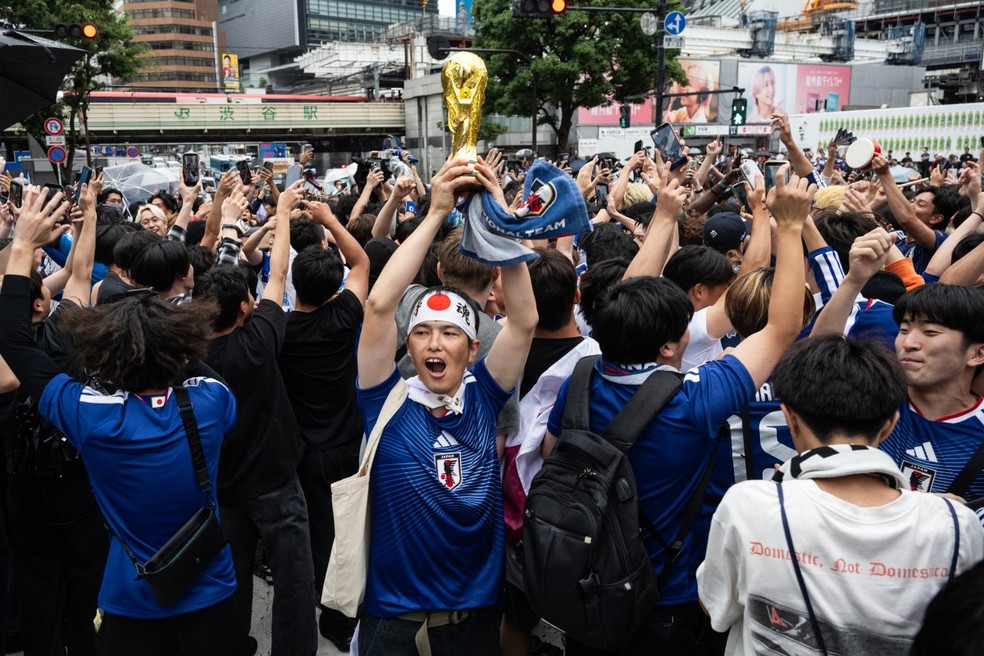 Torcedores comemoram no cruzamento de Shibuya após empate do Japão