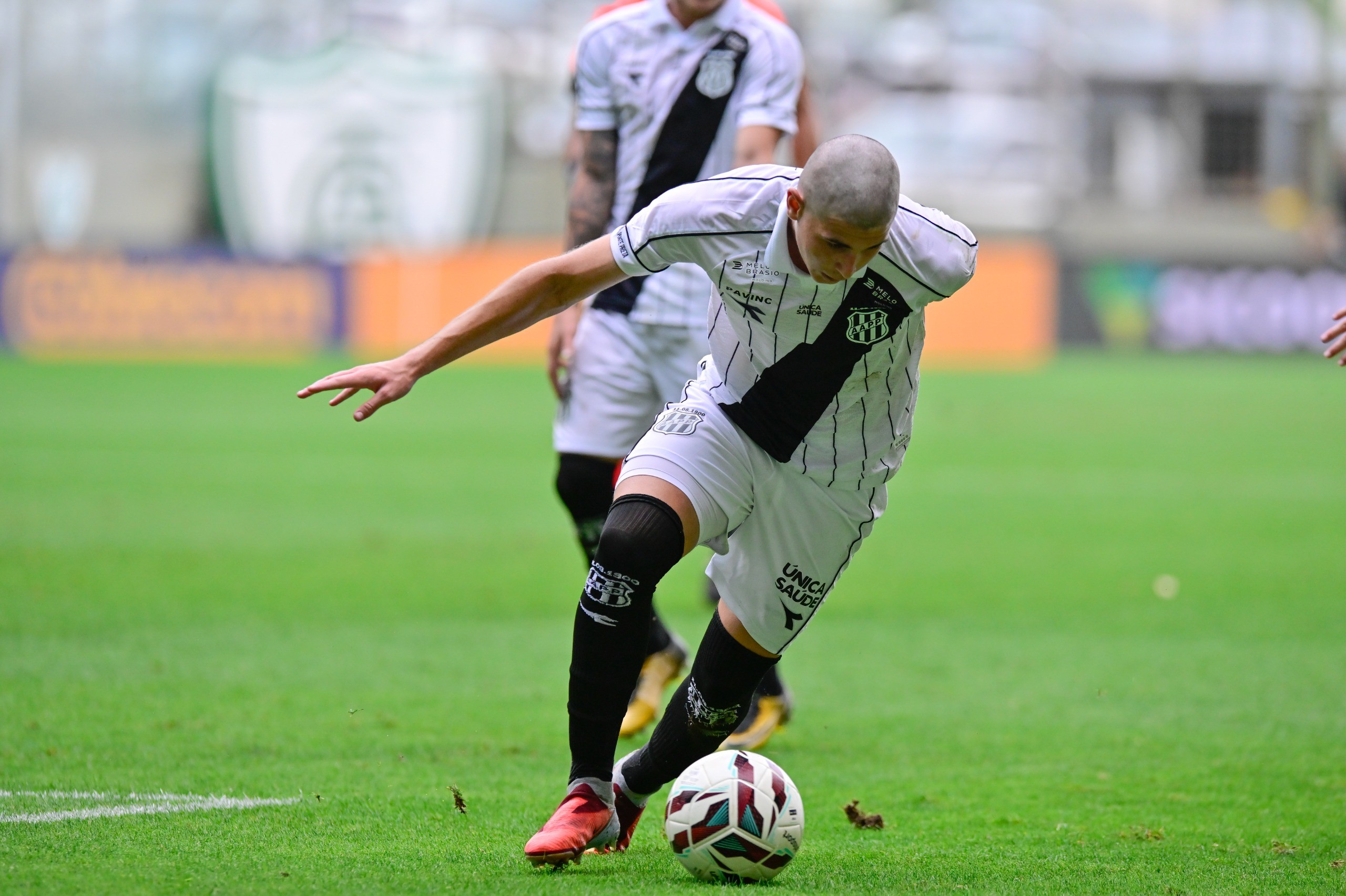 Jogadores da Ponte Preta em campo usando uniforme branco, em jogo contra América-MG