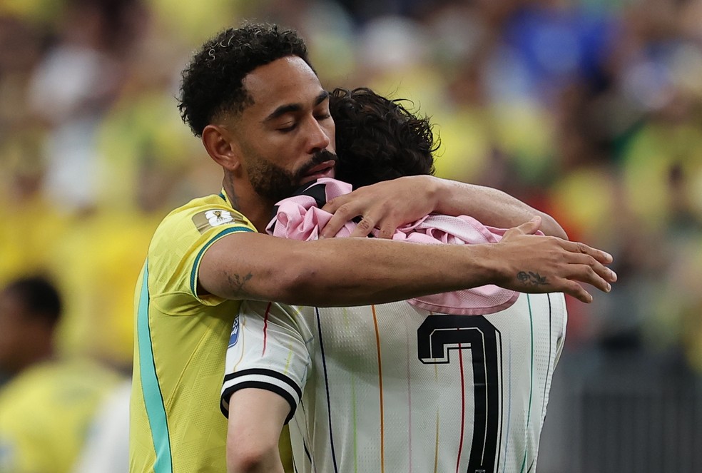 Matheus Cunha consola o japonês Tanaka — Foto: EFE/EPA/CHRISTOPHER NEUNDORF