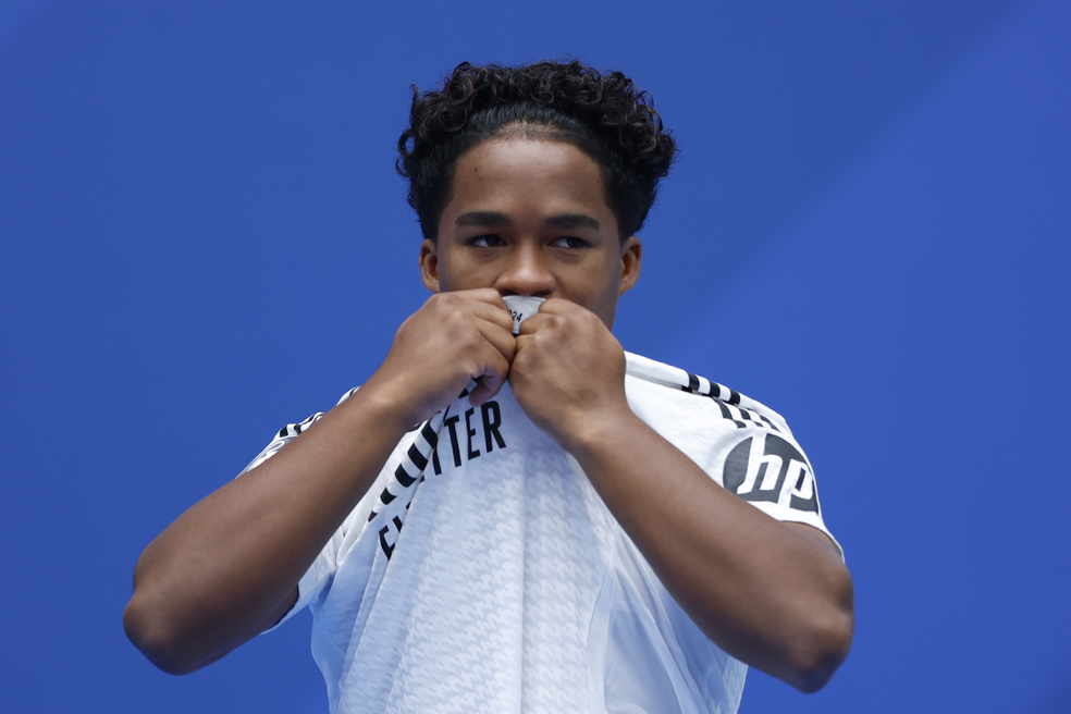 Endrick beija o escudo do Real Madrid na apresentação no Santiago Bernabéu — Foto: Mariscal/EFE