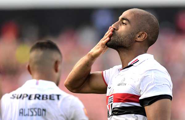 Jovem São-Paulino Lucas celebra classificação do time abraçando o pai no alambrado