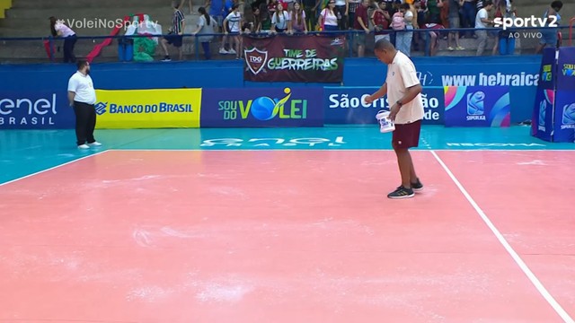 Trabalhadores jogam pó de magnésio para melhorar aderência da quadra, que sofre com umidade da chuva