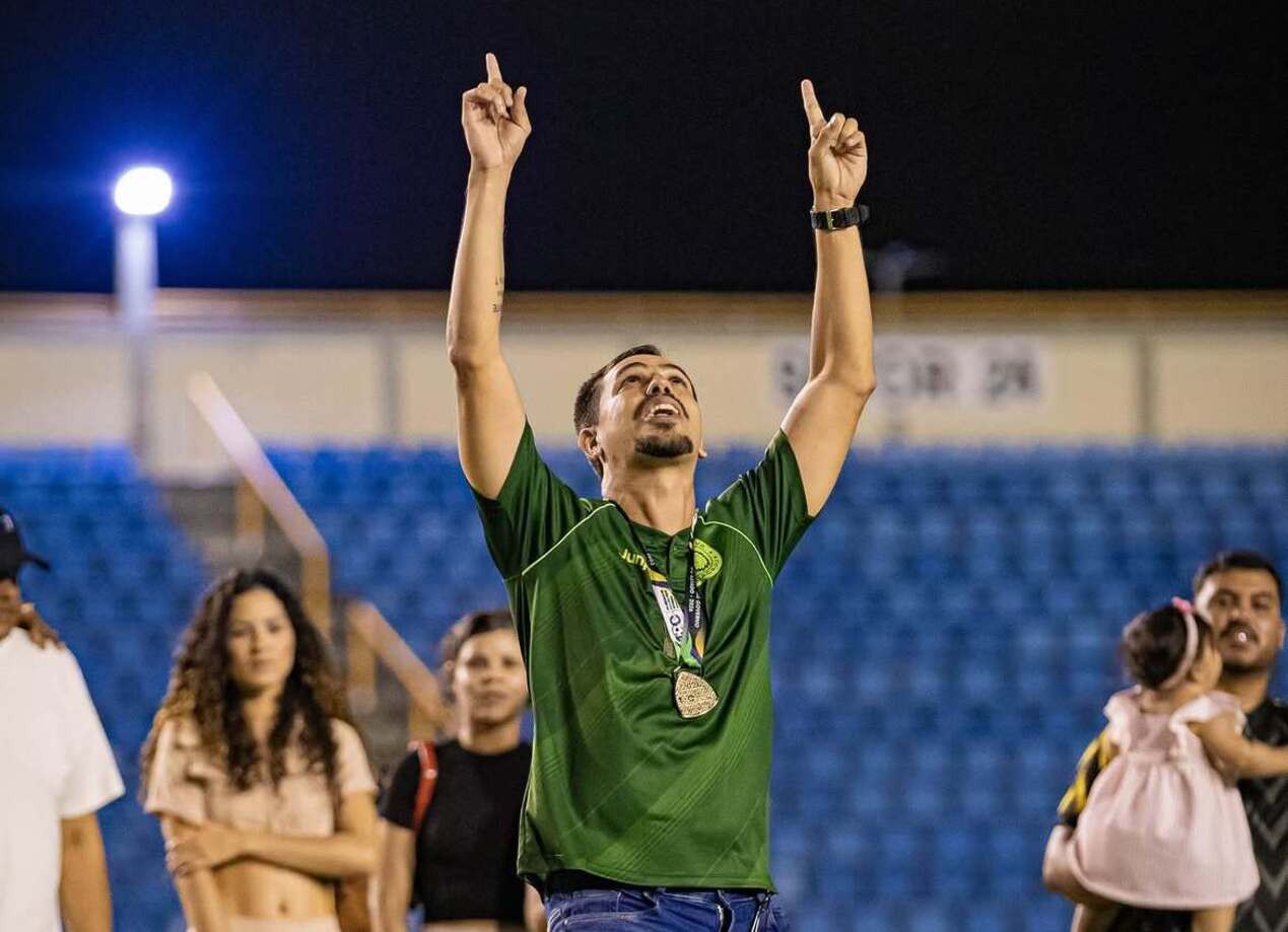 Treinador jovem comemorando ao lado do time campeão