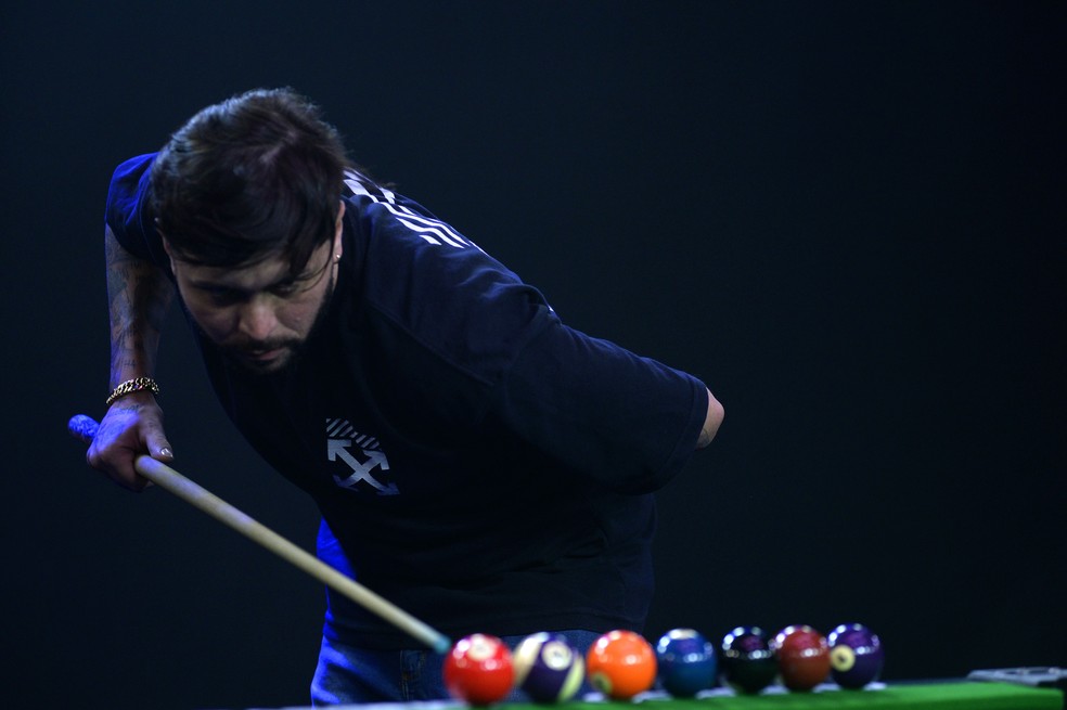 Felipinho encaçapa as bolas com uma mão no taco e outra nas costas  — Foto: Marcos Ribolli