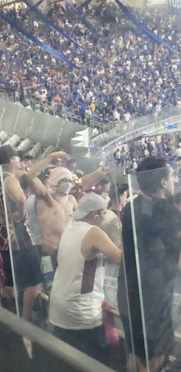 Torcedor do Lanús faz gestos racistas à torcida do Cruzeiro durante partida.