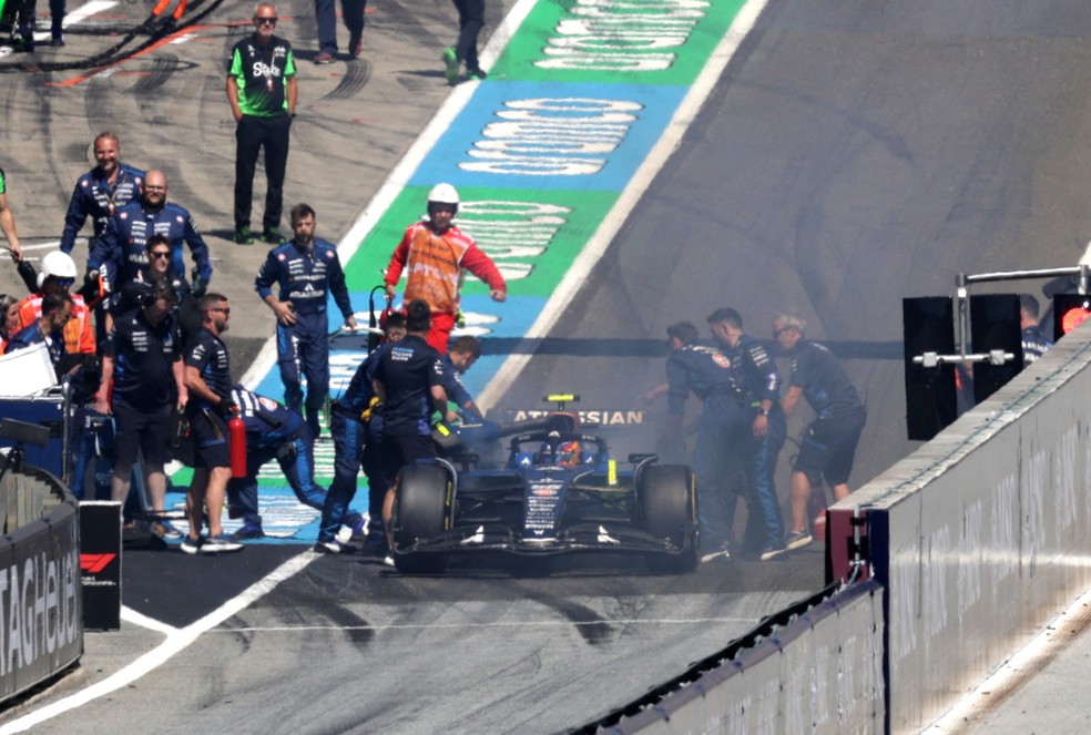 Mecânicos da Williams tentam conter fogo no carro de Carlos Sainz — Foto: Leonhard Foeger/Reuters