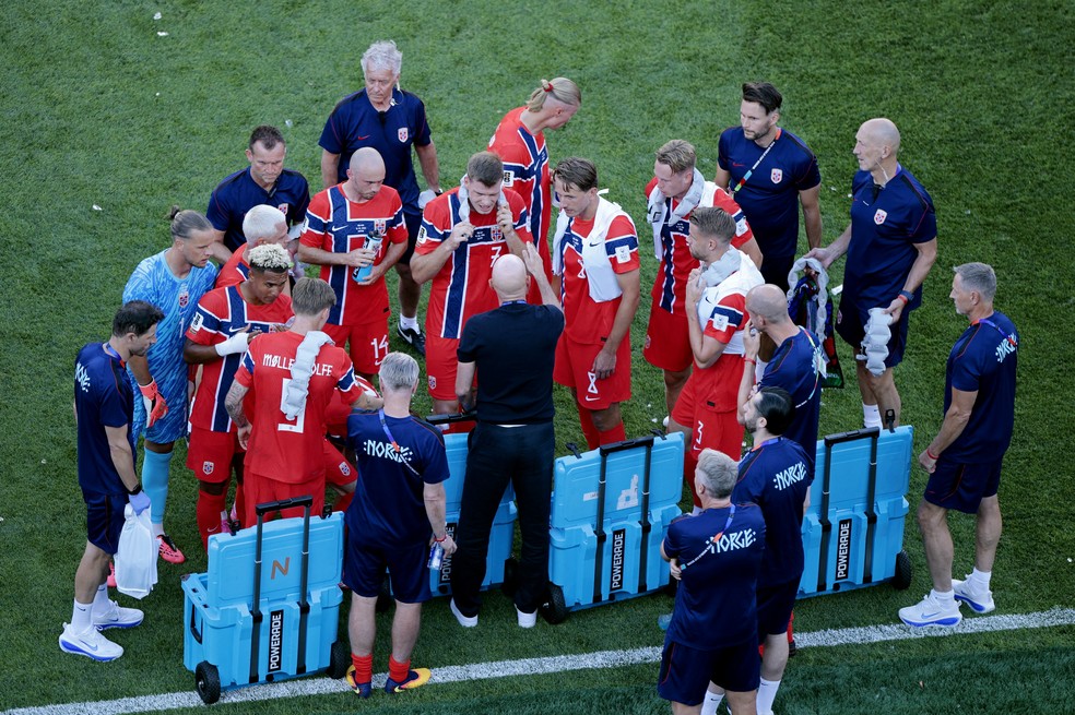Jogadores da Noruega com coletes de resfriamento durante a pausa