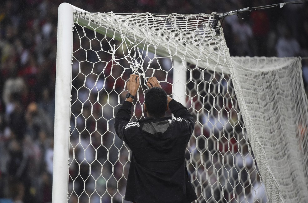 Funcionário conserta a rede do Maracanã — Foto: André Durão/ge