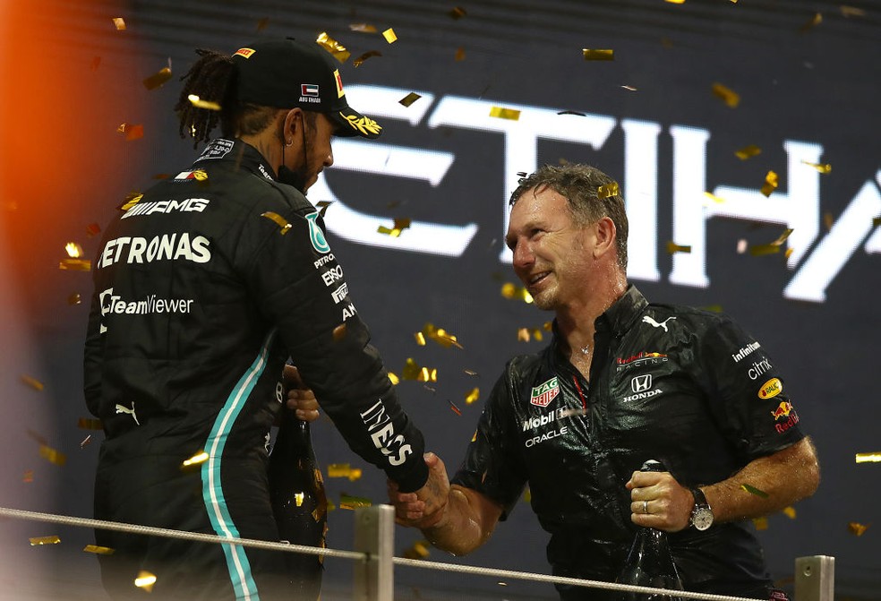 Lewis Hamilton e Christian Horner se cumprimentam após GP de Abu Dhabi de F1 2021, que cravou 1º Mundial de Max Verstappen — Foto: Joe Portlock - Formula 1/Formula 1 via Getty Images