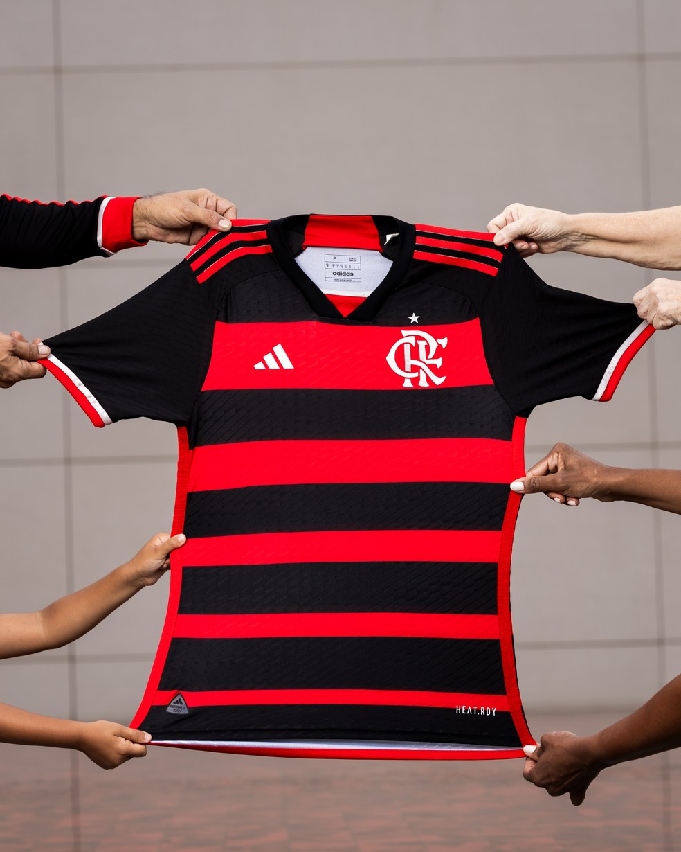 Olha a nova camisa do Flamengo segurada por torcedores de todas as cores — Foto: Divulgação/Adidas