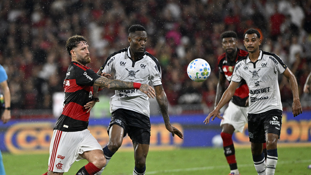 Léo Pereira disputa a bola com Tchamba