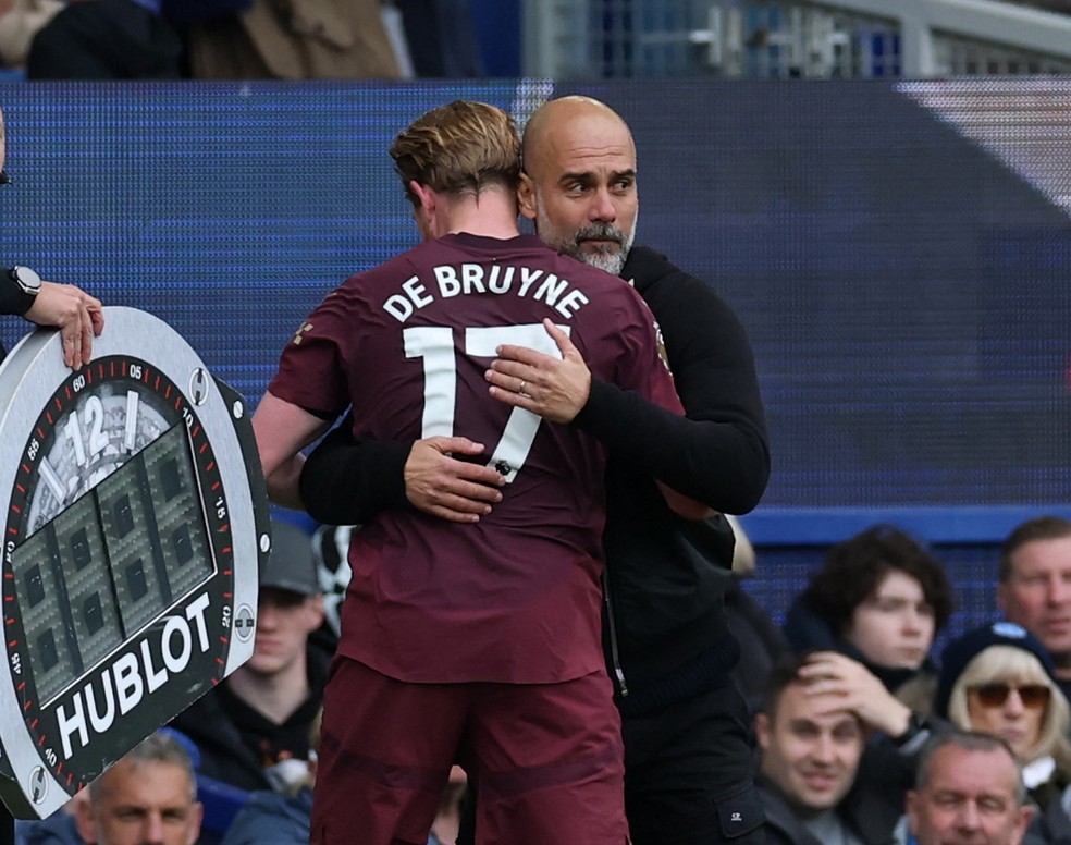 De Bruyne abraça Guardiola durante o jogo entre Everton e Manchester City, na Premier League — Foto: Reuters