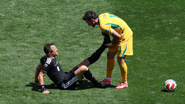 Árbitro Felix Zwayer é ajudado pelo jogador da Austrália Aiden O'Neill após sentir lesão