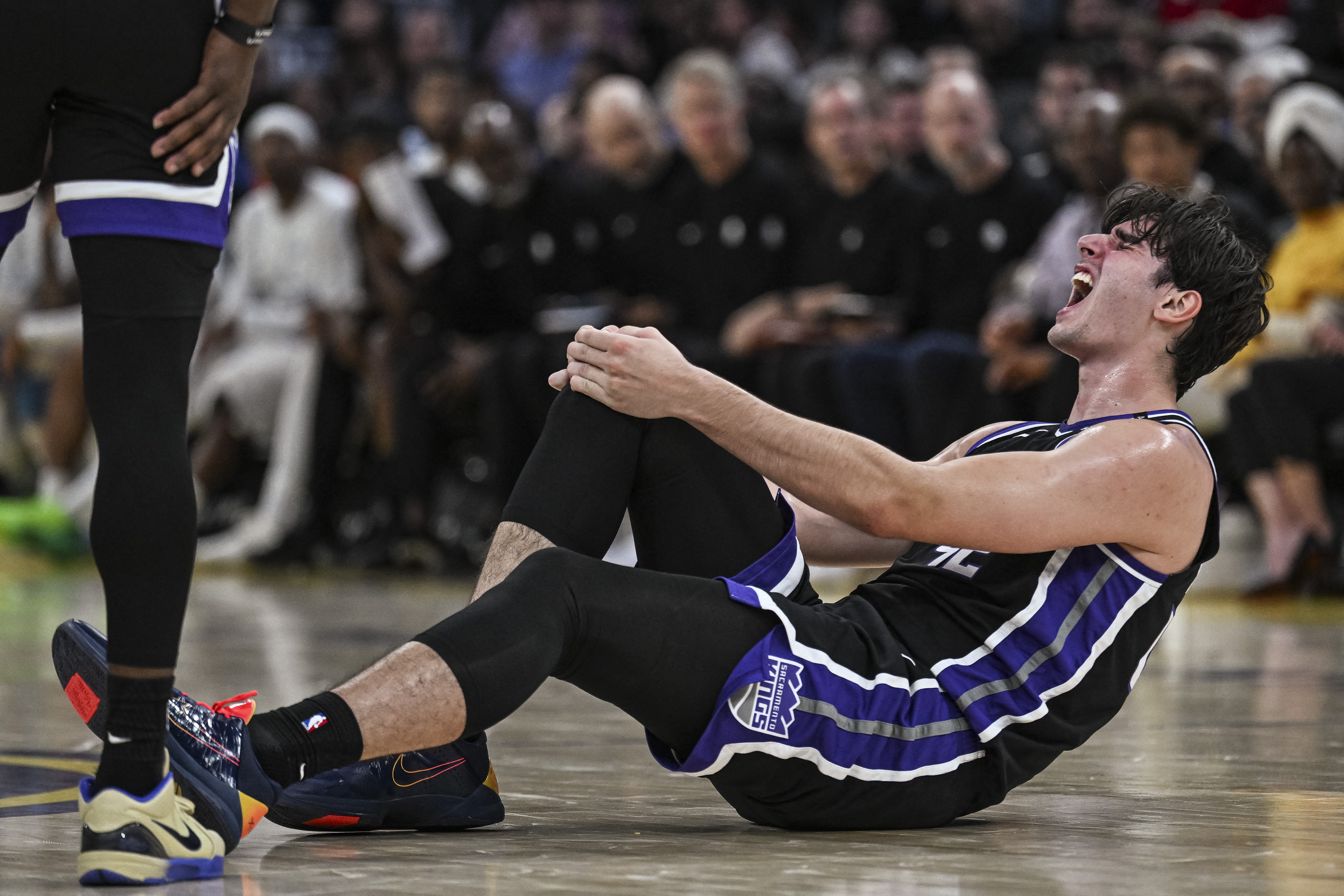 Pivô dos Kings sofre lesão no joelho e deixa quadra de cadeira de rodas após trombar com Curry