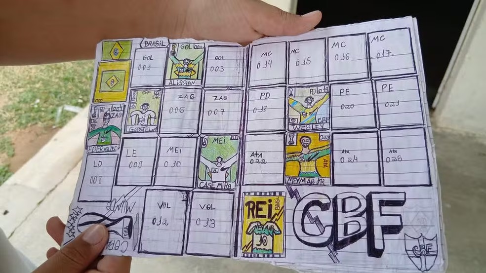 Menino mostrando páginas do álbum desenhado à mão