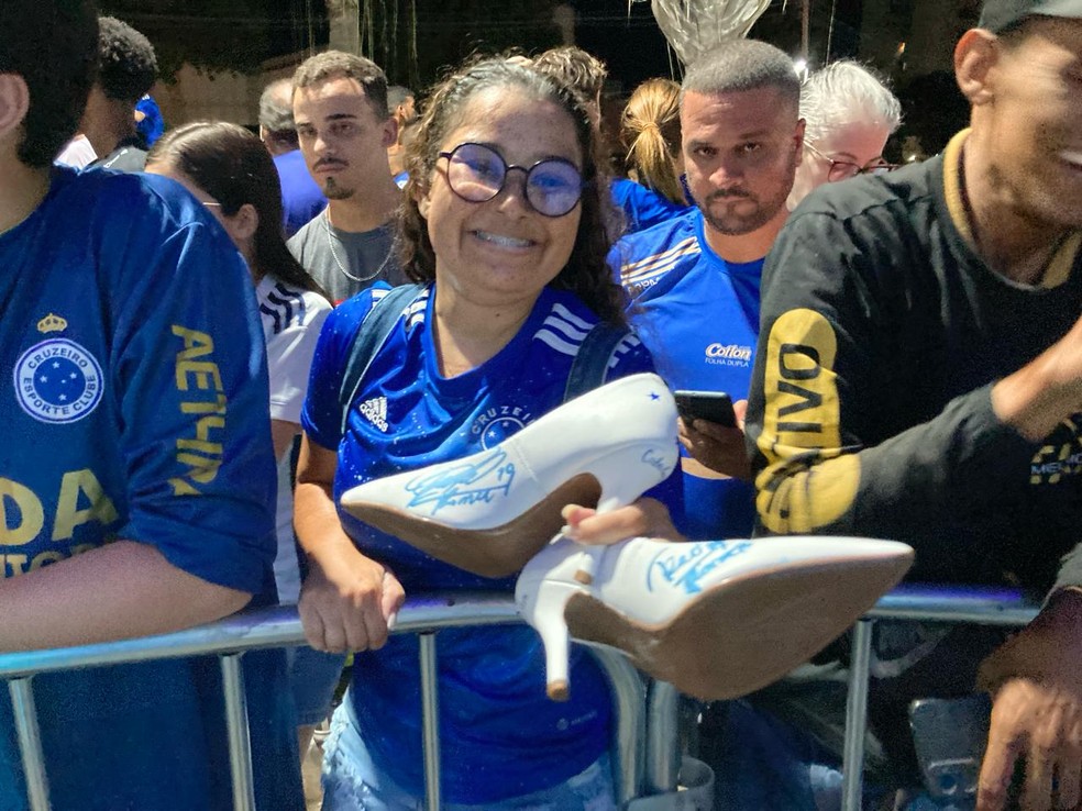 Torcedora do Cruzeiro exibe os sapatos autografados por Lucas Romero — Foto: Rodrigo Rocha