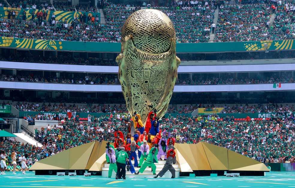 Artistas se apresentam ao lado de taça gigante da Copa do Mundo, na abertura, no México — Foto: Reuters