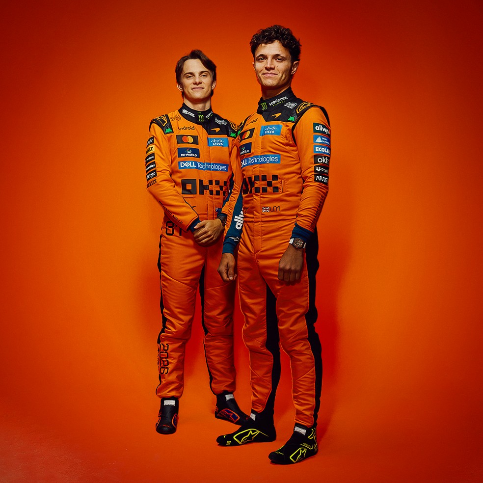 Oscar Piastri e o atual campeão da F1, Lando Norris, com uniformes de 2026 da McLaren — Foto: Divulgação