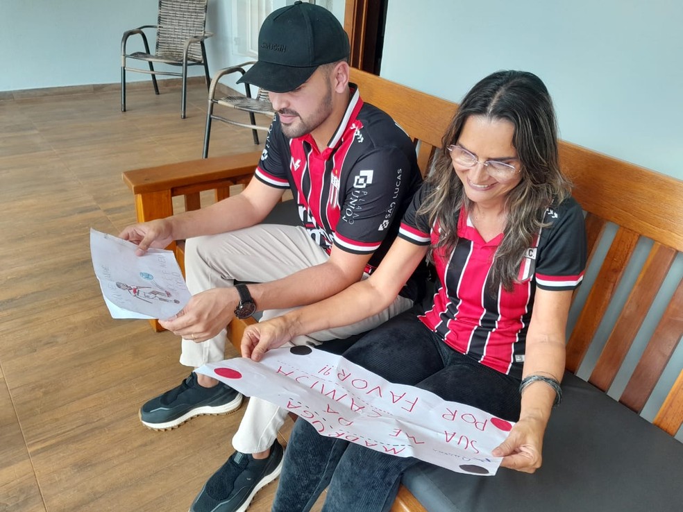 Gustavo Madruga e dona Ju com as cartinhas deixadas pelos fãs-mirins de Guilherme Madruga, do Botafogo — Foto: Vinícius Alves/ge